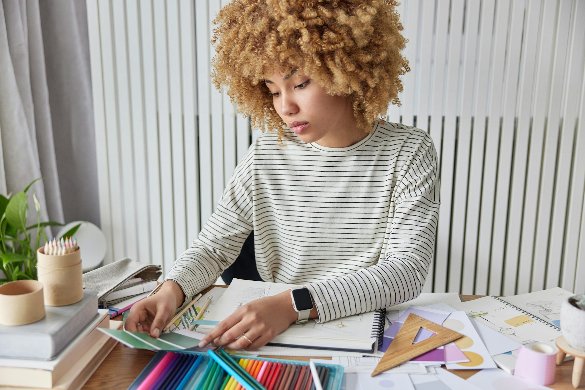 Creative female designer works on interior project chooses materials and details works with colour